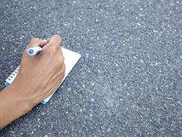 Person writing down her new ideas in a notebook photo