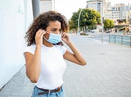 A beautiful African American woman donning a face mask. photo