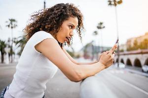 girl talking on a smartphone with surprise photo