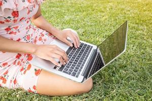 girl with a laptop on green grass photo