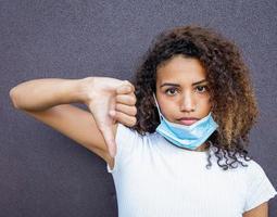 A beautiful African American woman with a misplaced face mask photo