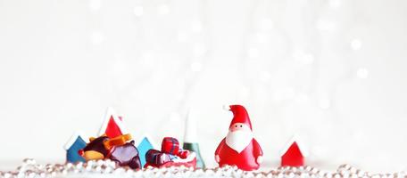 Santa Claus dolls and Christmas decorations box on abstract light background with copy space photo