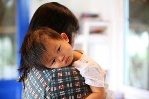 Portrait of sleepy asian baby with mother. Woman lifestyle mother's day concept. photo