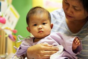 bebé asiático en el hospital con su madre. niño enfermo con su madre en el hospital foto