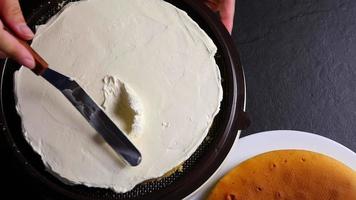 Top view of chef put cream on cake using spatula - people with homemade bakery concept video