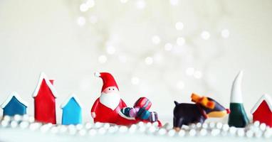 muñecos de santa claus y caja de adornos navideños sobre fondo claro abstracto con espacio de copia foto