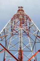 Telecommunication mast with microwave link and TV transmitter antennas over a blue sky. photo