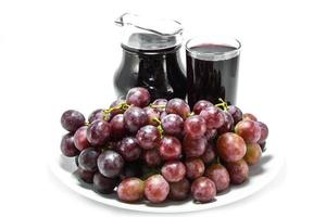 uva y jugo de uva en el fondo blanco foto