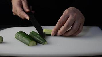 Chef cutting cucumber vegetable for making sushi - people with favorite dish Japanese food concept