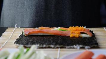 chef préparant un rouleau de sushi - personnes avec plat préféré concept de cuisine japonaise