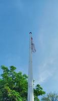 red and white flag fluttering against the blue sky background photo