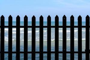 fence and blue wavy sea photo