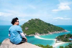 man on mountain peak with sea view photo