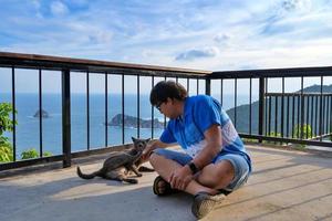 man sit and playing with cat photo