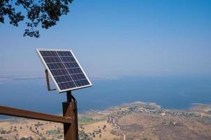 solar panels on hill with dam view in misty air photo