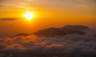 pico dorado de la montaña del amanecer con mar de nubes. perfecto para el fondo de la naturaleza y el papel tapiz. foto profesional