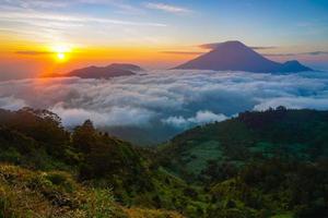 Golden sunrise mountain peak with sea of clouds. Perfect for nature background and wallpaper. Pro photo