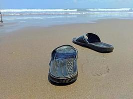 un par de sandalias en la playa foto