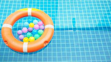 boya de vida y bolas de colores en la piscina foto