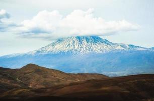 Landscape of snowy mountain ararat peak with cloud pass from Turkey side in spring. At the foot of mt Ararat photo