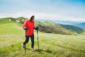 Female hiker nordic walk trekking outdoors in spring nature. Ikvlivi mount loop hike. photo