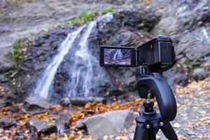 Shooting a waterfall on a video camera with a tripod photo