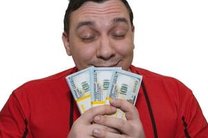 Happy man holds money in his hands and inhales their fragrance photo