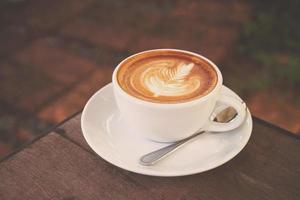 taza de café con leche en una cafetería con tono de color antiguo foto