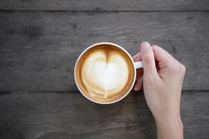 woman hands holding Latte art, coffee cup photo