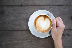 woman hands holding Latte art, coffee cup photo