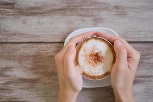 woman hands holding Latte art, coffee cup photo