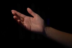 woman hands palms up over black background photo