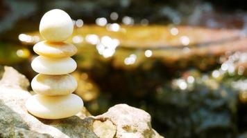 The Balance Stones are stacked as pyramids in a soft natural bokeh background, representing the calm philosophical concept of Jainism's wellness. photo