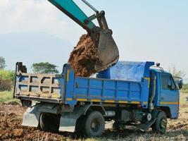 Excavadora cargadora de ruedas y basculante volquete. foto