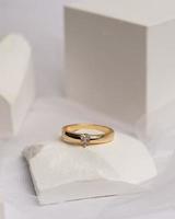 Wedding ring set on white stone. The jewelry ring is ready to be showcased and sold. The wedding ring is a sign of the love of the couple. Pearls and diamonds complete the ring's beauty. focus blur. photo