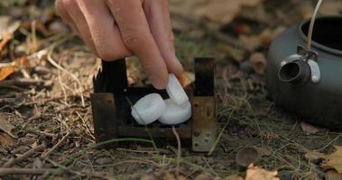 Close up of solid fuel stove with water kettle on fire, tea or coffee prepearing outdoors video