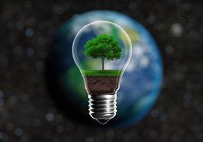 Green seedlings in a light bulb alternative energy concept, against a blurred background of planet Earth in space photo
