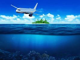 Airplane flying above tropical sea with island. Underwater view. photo