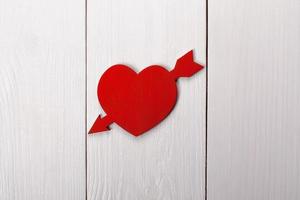 corazón atravesado por una flecha sobre una mesa. día de San Valentín, foto