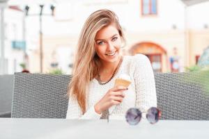 Portrait of young happy woman eating ice-cream, outdoor photo