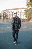 Young stylish man in black clothes in autumn day photo