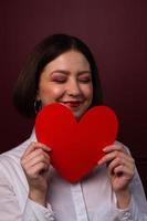 smailing mujer de pelo corto con los ojos cerrados con forma de corazón foto