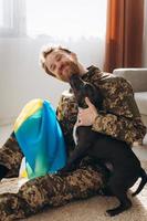 Ukrainian soldier hugging and wrapping his faithful friend's Ukrainian flag around an Amstaff dog in the office photo