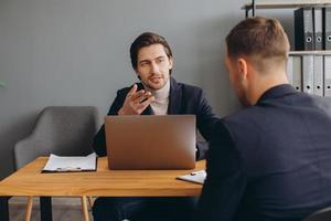 Recruiter during business job interview in office with male candidate photo