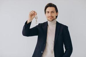 Portrait Of Cheerful Professional Real Estate Agent Holding Clipboard And Showing Keys In Hand, Selective Focus. photo