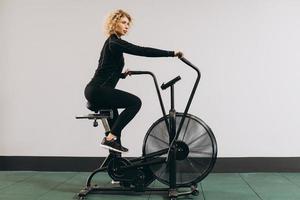 mujer crossfit haciendo entrenamiento cardiovascular intenso en bicicleta de aire foto