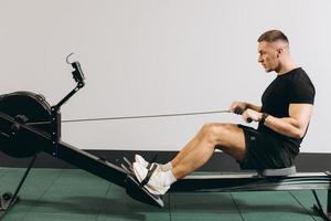 hombre corriendo ejercicio de remo en el gimnasio foto