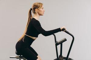 Crossfit woman doing intense cardio training on exercise air bike photo