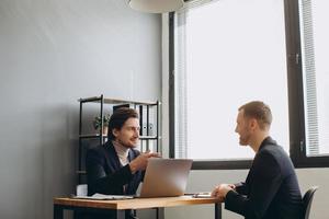 Recruiter during business job interview in office with male candidate photo