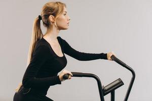 mujer crossfit haciendo entrenamiento cardiovascular intenso en bicicleta de aire foto